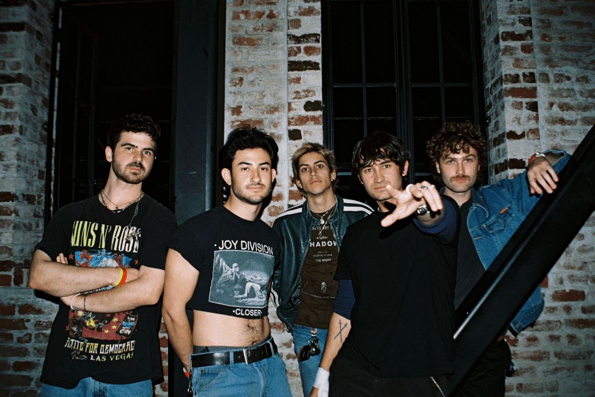 Band portrait of Hardcastle taken with flash against a light brick wall.